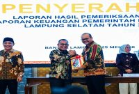 Kepala BPK Perwakilan Provinsi Lampung Nugroho Heru Wibowo menyerahkan Laporan Hasil Pemeriksaan atas LKPD Tahun 2025 kepada Wakil Bupati Lampung Selatan M. Syaiful Anwar, disaksikan Wakil Ketua II DPRD A. Benny Raharjo, di Auditorium BPK Lampung, 29 Mei 2026. Lampung Selatan kembali raih opini WTP. Foto: Humas DPRD Lamsel