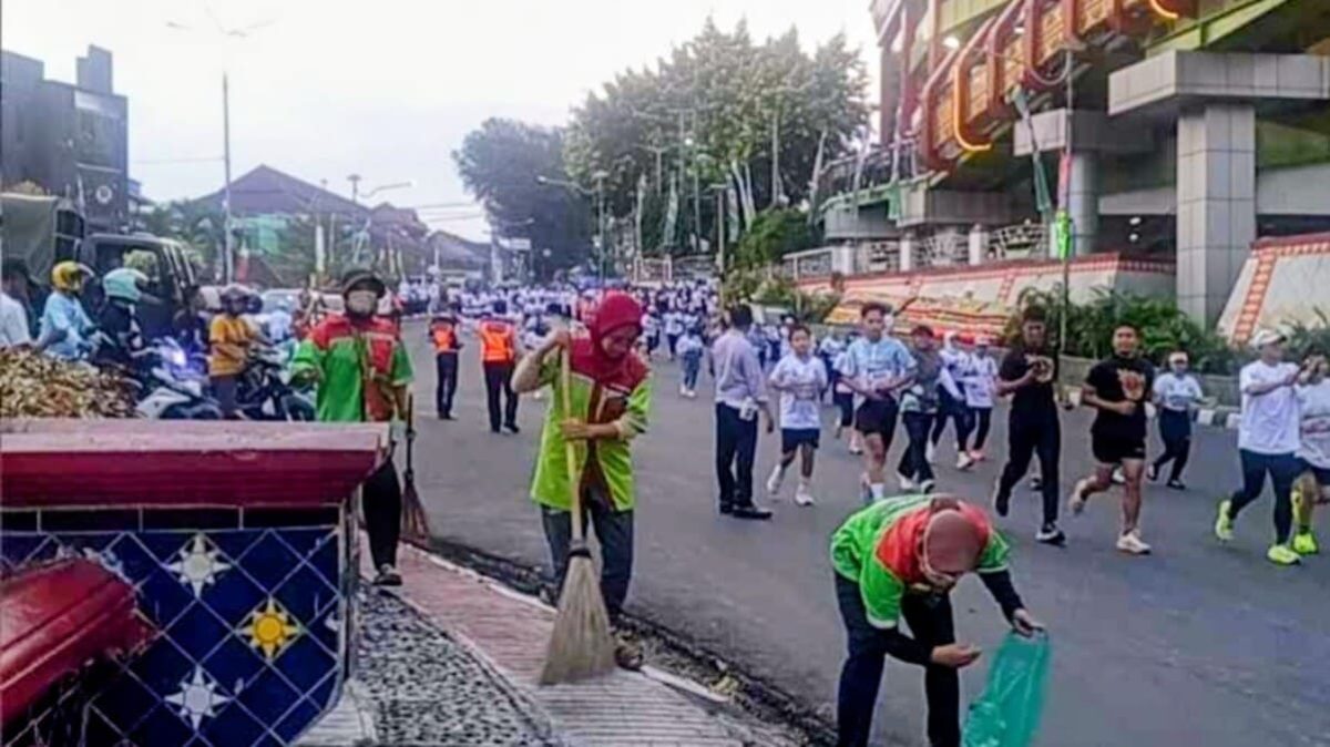 Petugas kebersihan Dinas Lingkungan Hidup DLH Kota Bandar Lampung membersihkan jalur BDL Color Run 2026 di tengah keramaian peserta, Minggu 21/6/2026. Sebanyak 154 petugas dikerahkan untuk menjaga kebersihan kota selama acara HUT ke-344 Bandar Lampung. PROYEKSI.ID