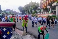 Petugas kebersihan Dinas Lingkungan Hidup DLH Kota Bandar Lampung membersihkan jalur BDL Color Run 2026 di tengah keramaian peserta, Minggu 21/6/2026. Sebanyak 154 petugas dikerahkan untuk menjaga kebersihan kota selama acara HUT ke-344 Bandar Lampung. PROYEKSI.ID