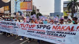 Massa Aliansi Masyarakat Lampung Dukung MBG AMAL MBG membawa spanduk "TUTUP SPPG NAKAL! YANG MENGKORUPSI JATAH MAKAN ANAK-ANAK SEKOLAH" saat aksi damai di Bandar Lampung, Senin 22/6/2026. Mereka menegaskan dukung program MBG dilanjutkan dan Presiden Prabowo, tapi desak koruptor MBG diproses hukum. FOTO : PROYEKSI.ID
