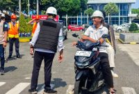 General Manager ASDP Bakauheni Partogi Tamba berdialog dengan pengguna jasa sepeda motor saat peninjauan penerapan sterilisasi pelabuhan di Pelabuhan Bakauheni, Lampung Selatan, Minggu 1 Juni 2026.