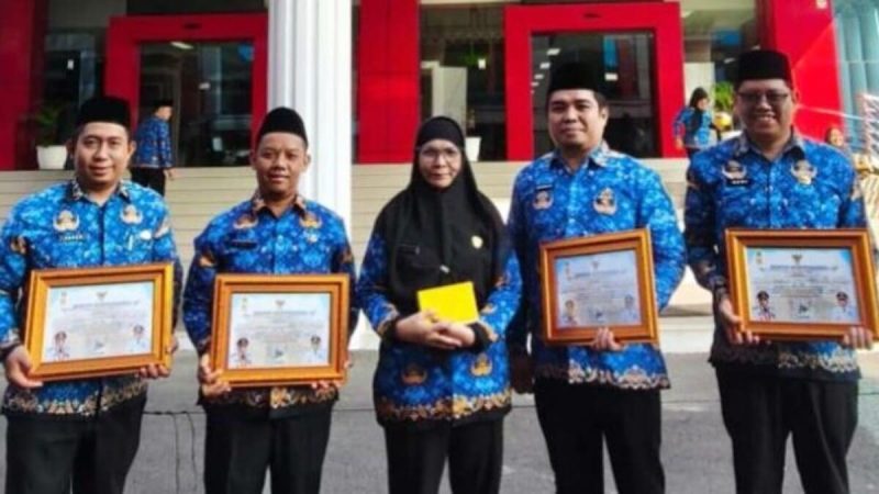 Asisten ll Pemkot Bandar Lampung Eka Afriana (tengah) berfoto bersama 4 kepala SDN penerima penghargaan akreditasi perpustakaan. Keempatnya yaitu Kepala SDN 1 Sukarame Dua, SDN 3 Gulak Galik, SDN 1 Keteguhan, dan SDN 1 Labuhan Ratu. Penyerahan berlangsung usai upacara Hari Lahir Pancasila, Senin 1 Juni 2026. Foto: istimewa
