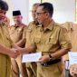 Plt Kepala Dinas Pendidikan dan Kebudayaan Kota Bandar Lampung M. Nur Ramdhan menyerahkan simbolis BOSDa SMP 2026 kepada perwakilan kepala sekolah. Pemkot mulai menyalurkan bantuan Rp300 ribu per siswa mulai 2 Juni 2026.