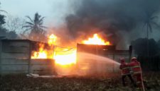 Dua petugas Damkar Lampung Selatan dan Pesawaran menyemprotkan air ke kobaran api yang membakar gudang CPO ilegal di Desa Negeri Sakti, Gedong Tataan, Pesawaran, Senin 8 Juni 2026 pukul 15.30 WIB. Api membumbung tinggi disertai asap hitam pekat. Kerugian ditaksir Ratusan juta rupiah. Foto: PROYEKSI.ID