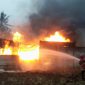 Dua petugas Damkar Lampung Selatan dan Pesawaran menyemprotkan air ke kobaran api yang membakar gudang CPO ilegal di Desa Negeri Sakti, Gedong Tataan, Pesawaran, Senin 8 Juni 2026 pukul 15.30 WIB. Api membumbung tinggi disertai asap hitam pekat. Kerugian ditaksir Ratusan juta rupiah. Foto: PROYEKSI.ID