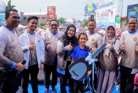 Wali Kota Bandar Lampung Eva Dwiana mendampingi Ernawati Ningsih dan anaknya saat penyerahan kunci replika mobil Daihatsu Sigra, hadiah utama jalan sehat HUT ke-344 Kota Bandar Lampung di Tugu Adipura, Minggu (28/6/2026). PROYEKSI.ID