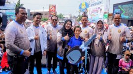 Wali Kota Bandar Lampung Eva Dwiana mendampingi Ernawati Ningsih dan anaknya saat penyerahan kunci replika mobil Daihatsu Sigra, hadiah utama jalan sehat HUT ke-344 Kota Bandar Lampung di Tugu Adipura, Minggu (28/6/2026). PROYEKSI.ID
