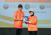 Gubernur Lampung Rahmat Mirzani Djausal menyerahkan buku kepada Kepala BPS RI Amalia Adininggar Widyasanti dalam Apel Siaga dan Penguatan Komitmen Bersama Sensus Ekonomi 2026 di Lapangan KORPRI Pemprov Lampung, Bandar Lampung, Sabtu (27/6/2026). Foto: Dok. Proyeksi.id