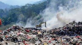 Petugas dan alat berat terlihat di tengah kepulan asap di Tempat Pemrosesan Akhir (TPA) Bakung, Kota Bandar Lampung, Kamis (9/7/2026). DLH menyiagakan tandon air di titik strategis sebagai langkah antisipasi kebakaran sampah saat musim kemarau. Foto: proyeksi.id