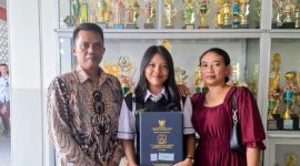 Gusti Made Ayu Yuli Asmarani (tengah) berfoto bersama ayah dan ibunya di SMA Yos Sudarso Metro. Putri seorang petani ini kini melanjutkan pendidikan di Prodi Akuntansi IIB Darmajaya dengan cita-cita bekerja di industri perbankan.