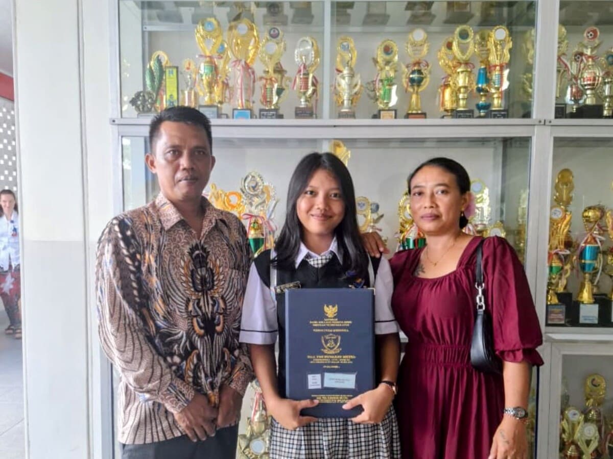 Gusti Made Ayu Yuli Asmarani (tengah) berfoto bersama ayah dan ibunya di SMA Yos Sudarso Metro. Putri seorang petani ini kini melanjutkan pendidikan di Prodi Akuntansi IIB Darmajaya dengan cita-cita bekerja di industri perbankan.