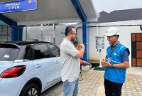 Petugas PLN menjelaskan cara pengisian daya kepada pengguna mobil listrik Wuling Binguo EV di SPKLU PLN Lampung. SPKLU UP3 Tanjung Karang tercatat paling ramai dengan 3.114 kali transaksi. Foto: Proyeksi.id