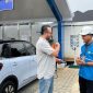 Petugas PLN menjelaskan cara pengisian daya kepada pengguna mobil listrik Wuling Binguo EV di SPKLU PLN Lampung. SPKLU UP3 Tanjung Karang tercatat paling ramai dengan 3.114 kali transaksi. Foto: Proyeksi.id