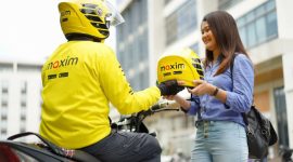 Seorang mitra pengemudi Maxim Bike menyerahkan helm kepada penumpang sebagai standar keselamatan layanan. Maxim resmi membuka kantor operasional di Bakauheni, Lampung Selatan, dengan layanan Bike, Car, hingga Food and Shop. (Foto: Dok. Maxim)