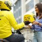 Seorang mitra pengemudi Maxim Bike menyerahkan helm kepada penumpang sebagai standar keselamatan layanan. Maxim resmi membuka kantor operasional di Bakauheni, Lampung Selatan, dengan layanan Bike, Car, hingga Food and Shop. (Foto: Dok. Maxim)
