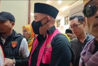  Terdakwa kasus dugaan korupsi SPAM, mantan Bupati Pesawaran Dendi Romadhona, berjalan keluar ruang sidang PN Tipikor Tanjungkarang dengan tangan diborgol, Jumat (3/7/2026). Seorang wartawan mengaku mengalami intimidasi saat merekam momen ini. Foto: ist