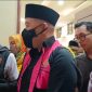  Terdakwa kasus dugaan korupsi SPAM, mantan Bupati Pesawaran Dendi Romadhona, berjalan keluar ruang sidang PN Tipikor Tanjungkarang dengan tangan diborgol, Jumat (3/7/2026). Seorang wartawan mengaku mengalami intimidasi saat merekam momen ini. Foto: ist