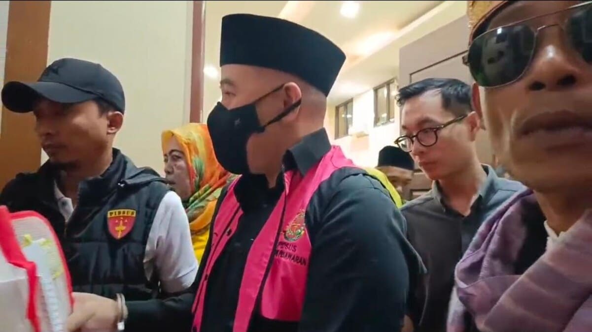 Terdakwa kasus dugaan korupsi SPAM, mantan Bupati Pesawaran Dendi Romadhona, berjalan keluar ruang sidang PN Tipikor Tanjungkarang dengan tangan diborgol, Jumat (3/7/2026). Seorang wartawan mengaku mengalami intimidasi saat merekam momen ini. Foto: ist