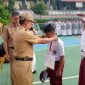 Kepala SMP Negeri 2 Bandar Lampung Abdul Khanif, M.Pd (tengah) mengalungkan tanda peserta kepada perwakilan siswa baru saat pembukaan Masa Pengenalan Lingkungan Sekolah (MPLS) Ramah Tahun Ajaran 2026/2027 di lapangan SMPN 2 Bandar Lampung, Senin (13/7/2026). MPLS Ramah berlangsung 13-17 Juli 2026 dengan mengedepankan pendekatan humanis, inklusif, dan anti perundungan. foto : istimewa
