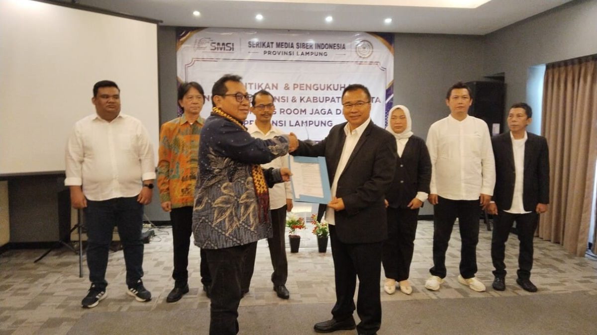 Ketua Umum SMSI Pusat Firdaus menyerahkan SK kepada Ketua SMSI Lampung Donny Irawan pada Pelantikan dan Pengukuhan Pokja Newsroom Jaga Desa tingkat Provinsi dan Kabupaten/Kota se-Lampung di Yunna Hotel, Kamis (16/7/2026). Pokja ini dibentuk untuk mengawal dana desa agar transparan dan mencegah penyimpangan hukum. FOTO: PROYEKSI.ID
