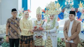 BANDAR LAMPUNG - Gubernur Lampung Rahmat Mirzani Djausal bersama Ketua TP PKK Provinsi Lampung Purnama Wulan Sari Mirza menyaksikan penyerahan mahar kepada salah satu pasangan peserta Nikah Massal Begawi Cinta Lampung 2026 di Ballroom Masjid Raya Al-Bakrie, Sabtu (25/7/2026). Sebanyak 31 pasangan mengikuti program pernikahan gratis yang digagas Pemprov Lampung dan Masjid Raya Al-Bakrie tersebut. Foto: istimewa
