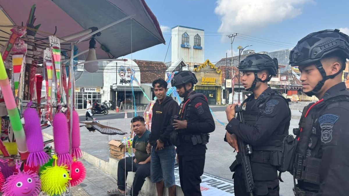 BANDAR LAMPUNG - Personel Detasemen Gegana Satbrimob Polda Lampung berdialog dengan pedagang saat melakukan patroli dialogis di kawasan keramaian Bandar Lampung, Minggu (26/7/2026). Kegiatan ini menyasar tempat ibadah, pasar, dan pusat aktivitas warga untuk memastikan situasi tetap kondusif. FOTO: DOK/SATBRIMOB POLDA LAMPUNG