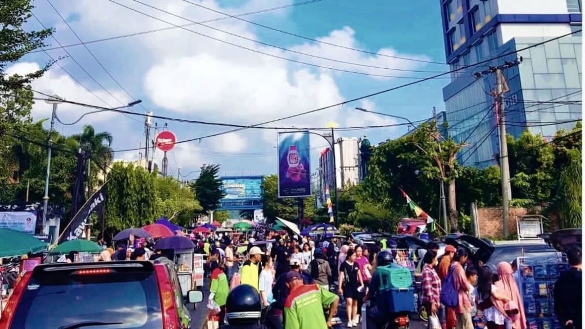 BANDAR LAMPUNG - Suasana Car Free Day di kawasan Tugu Adipura, Jalan Radin Intan, Bandar Lampung, Minggu (26/7/2026). Ribuan warga memadati lokasi untuk berolahraga dan berbelanja di lapak UMKM. Warga dan pedagang berharap waktu CFD diperpanjang karena pengunjung masih ramai setelah pukul 09.00 WIB. Foto: PROYEKSI.ID