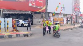 BANDAR LAMPUNG - Personel Pos Lantas Tugu Adipura Polresta Bandar Lampung membagikan paket makanan gratis kepada pengendara saat kegiatan Jumat Berkah di depan Pos Lantas Tugu Adipura, Jumat (17/7/2026). FOTO: PROYEKSI.ID