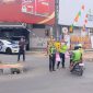BANDAR LAMPUNG - Personel Pos Lantas Tugu Adipura Polresta Bandar Lampung membagikan paket makanan gratis kepada pengendara saat kegiatan Jumat Berkah di depan Pos Lantas Tugu Adipura, Jumat (17/7/2026). FOTO: PROYEKSI.ID