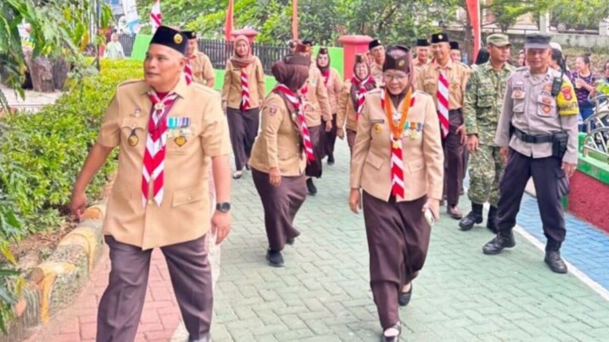 Wakil Ketua I Kwarcab Gerakan Pramuka Kota Bandar Lampung Hj. Eka Afriana, S.Pd berjalan menuju lokasi apel peringatan Hari Pramuka ke-65 di SMPN 3 Bandar Lampung, Jumat (14/8/2026). FOTO: Istimewa