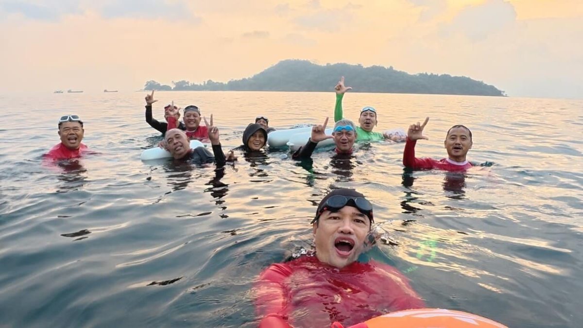 Anggota komunitas Perenang Antar Pulau berfoto di tengah laut Teluk Lampung, Sabtu (1/8/2026). Mereka menempuh jarak 2,3 km dari Pantai Mutun ke Pantai Kyoto, Pesawaran, di tengah rintik hujan dan ombak. [PROYEKSIID]