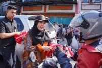 BANDAR LAMPUNG – Wali Kota Bandar Lampung Eva Dwiana membagikan bendera Merah Putih kepada pengendara motor di Jalan Yos Sudarso, Kecamatan Bumi Waras, Sabtu (8/8/2026). Sebanyak 10 ribu bendera dibagikan Pemkot untuk menyemarakkan HUT ke-81 Kemerdekaan RI. Foto: Proyeksi.id