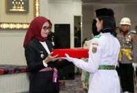 Wakil Gubernur Lampung Jihan Nurlela menyerahkan duplikat bendera pusaka kepada pemimpin Paskibraka Provinsi Lampung 2026 pada acara pengukuhan di Balai Keratun Lt. III Kantor Gubernur, Sabtu (15/8/2026). FOTO: PROYEKSI.ID