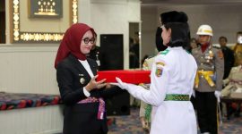 Wakil Gubernur Lampung Jihan Nurlela menyerahkan duplikat bendera pusaka kepada pemimpin Paskibraka Provinsi Lampung 2026 pada acara pengukuhan di Balai Keratun Lt. III Kantor Gubernur, Sabtu (15/8/2026). FOTO: PROYEKSI.ID
