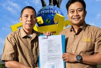 Wakil Ketua I SMSI Lampung Ahmad Syarif menyerahkan SK penunjukan Doni Alfarobbi sebagai Plt Ketua SMSI Kabupaten Pringsewu di depan Tugu Gajah Pringsewu. FOTO: DOK. SMSI LAMPUNG

